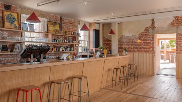 The long timber bar has a DJ booth built in so staff can easily play records while they're serving drinks.