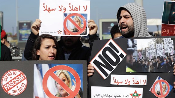 Lebanese protesters hold placards that read, "You are not welcome" during a protest against Ms Le Pen.