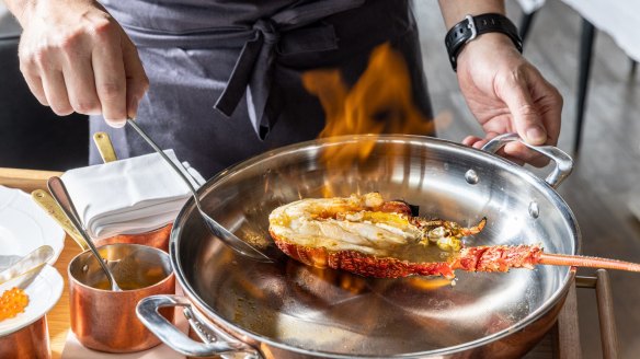 Lobster is flambeed in rum, tableside.