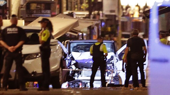 Police officers stand next to the van involved in an attack in Las Ramblas in Barcelona, Spain.