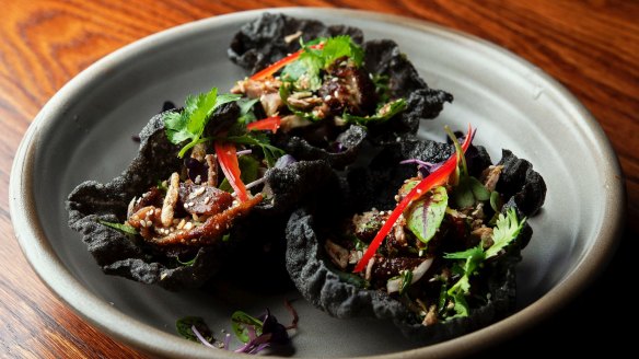 Tinder Creek roasted duck with squid ink rice cracker, toasted ground rice and sawtooth coriander.