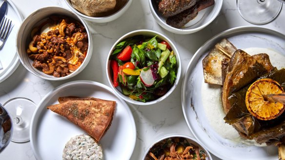 A selection of mezze including saj (bread), eggplant fatteh, fattoush, hummus, kingfish and kofta.