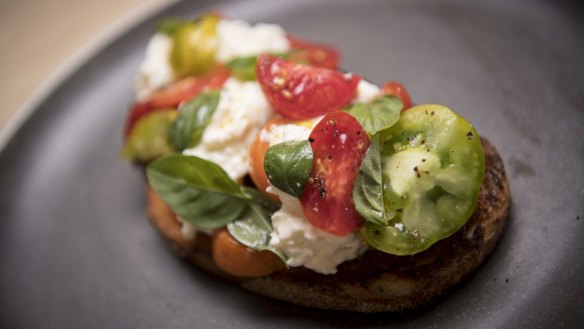 Stracciatella cheese, heirloom tomatoes and basil on sourdough toast.