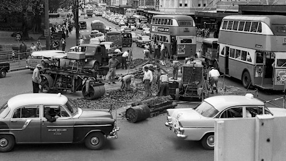 "But for Sydney motorists, even two years seems a long time to wait before they can expect a smoother ride..." Traffic jams in Elizabeth Street on 12 December 1961, due to workmen removing tram tracks.
