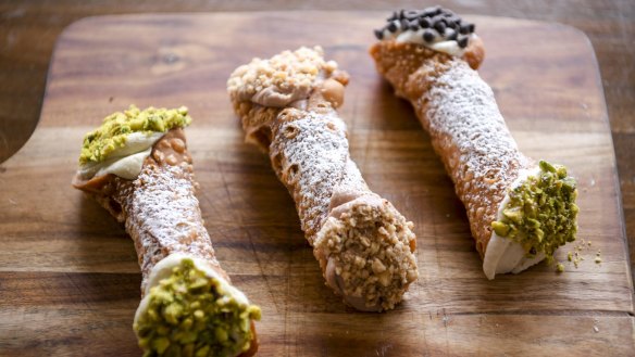 From left: Pistachio, Nutella and classic cannoli piped with ricotta-based fillings and dipped in crushed nuts and/or chocolate chips.