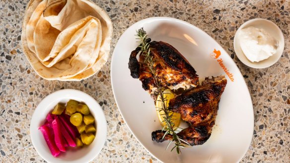 Charcoal chicken half with Lebanese bread, toum and pickles.
