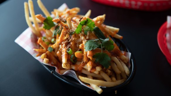 A bowl of pho-fries: hot chips topped with Sriracha mayo, hoisin, fried shallots and coriander. 