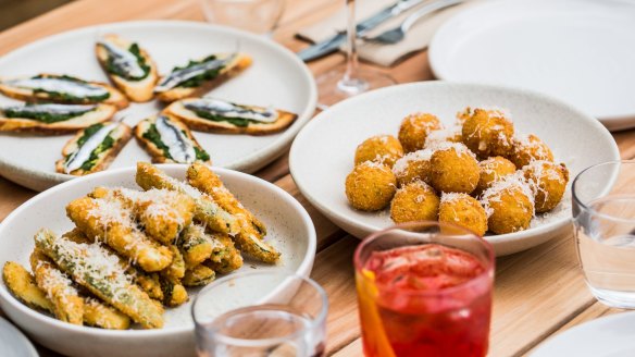 Expect an Italian restaurant menu, including white anchovy crostini (left rear), zucchini fritti (front) and arancini.