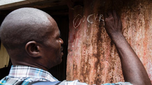 Workers conduct a door-to-door cholera vaccination.
