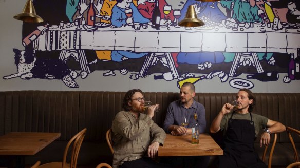 Giorgio De Maria (left), Mattia Dicati and Enrico Tomelleri with the Last Supper-style artwork.