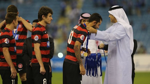 Western Sydney Wanderers players receive their medals after the game.