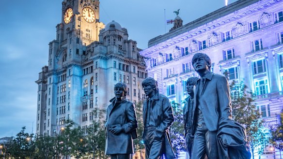 A life-size statue of The Beatles stand outside the "Three Graces" buildings.