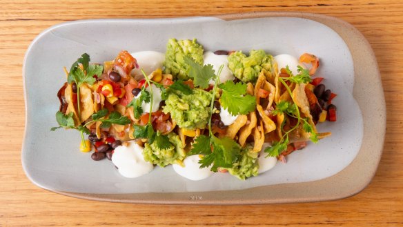 A roasted sweet potato sits beneath these loaded nachos.