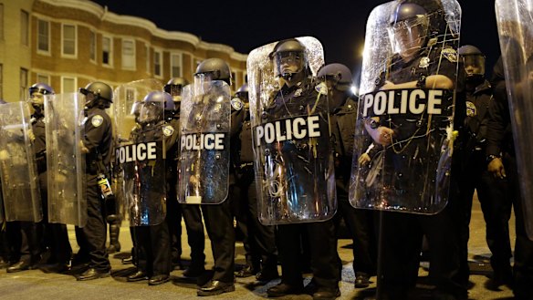 Police stand in formation as a curfew approaches in Baltimore, a day after unrest that occurred following Freddie Gray's funeral last month. 