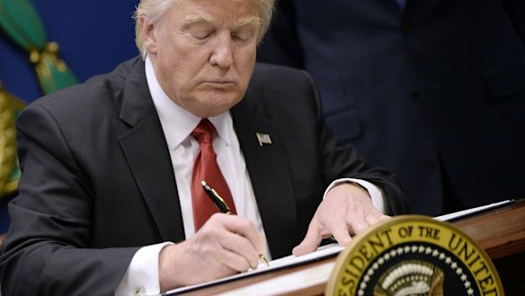 President Donald Trump signs an executive order in Washington.