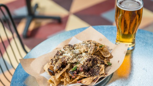 Beer and nachos with brisket mole served at Good Heavens above Fancy Hank's in Melbourne.