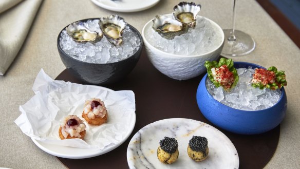 Opening snacks might include, clockwise from right: cos spooned with kingfish tartare and chilli-spiked tomato powder; nori-marbled brioche crowned with caviar; and deep-fried potato topped with raw scallop and salted-cherry sauce.