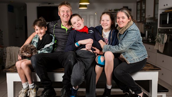 The McCarthy family is among those affected by the closure of respite services for people with high needs in Canberra. From left, Logans therapy dog Simi, Kellan 9, Jason, Logan 16, Jenna 14, and Lucy. 