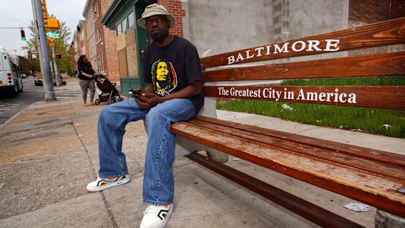 James Lewis waits for a bus in the Hollins Market area of Baltimore.