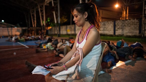 A pregnant woman awaits processing during a night time mass arrest of suspected drug users at a shanty community on in Manila last week.