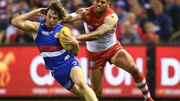 Sports fans are watching the action while digital signs scroll in the background.