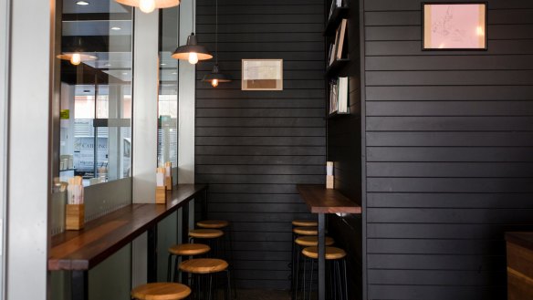 The interior is very black - one wall is black tiles with the white grout showing through, the other is painted black wood panelling.