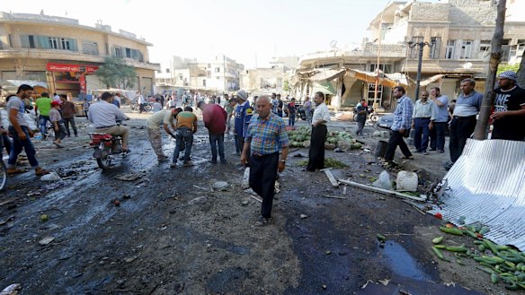 Residents gather at a market damaged by what activists said was an air strike by forces of Syria's President Bashar al-Assad on Tuesday.