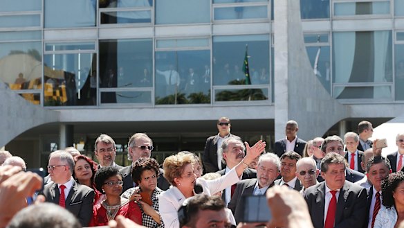Suspended Brazilian President Dilma Rousseff (centre) speaks to supporters outside the Planalto presidential palace after the Senate voted to accept impeachment charges against her. 