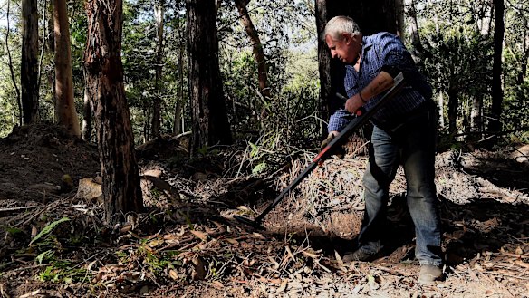 Mark Leveson uses a metal detector at the search site.