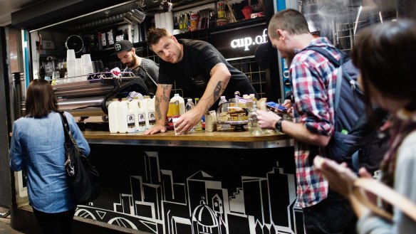 Baristas Jon Freeman (left) and Courtney Patterson serve coffee to commuters at Cup Of Truth.