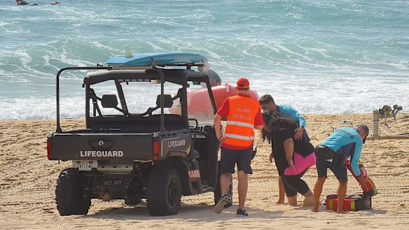 Mother Sandra Tomano is helped by lifesavers into their buggy on Tuesday.