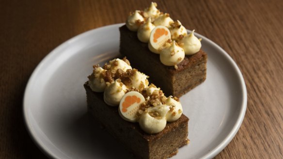Carrot cake is topped with architectural cream cheese swirls.