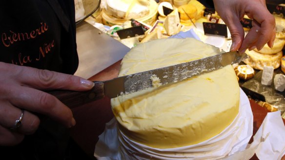 A woman cuts a slice of butter on a market in Bayonne, south-western France.