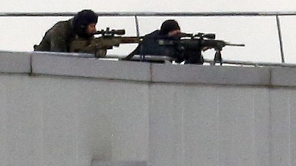 Before the assault ... French special forces take position with sniper rifles on the rooftop of a complex at an industrial building in Dammartin-en-Goele, northeast of Paris.