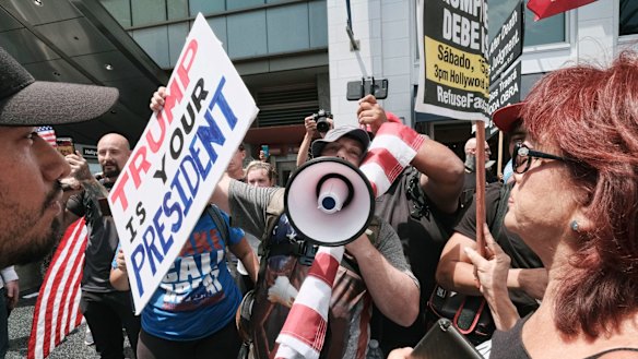 Supporters of President Donald Trump, left, sound off against anti-Trump protesters rallying on Hollywood Boulevard in Los Angeles on Saturday