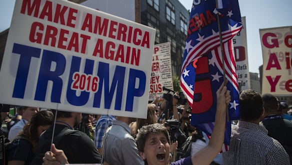 A supporter holds a campaign sign for Donald Trump in the Public Square  in Cleveland.