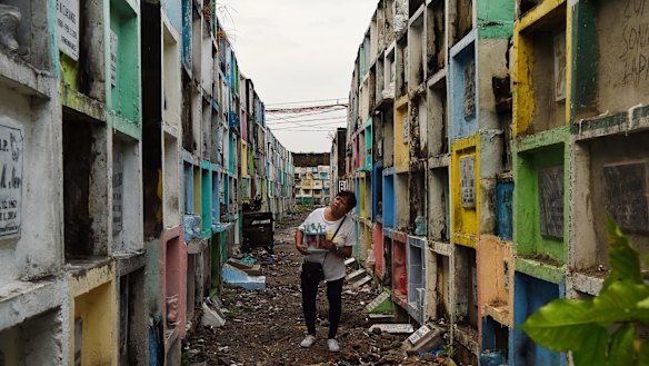 Elena de Chavez 61 holding a photo of her transgender son Alvin Ronald de Chavez also known as 'Heart', searches for his tomb at the Navotos Catholic Cemetery in Manila.