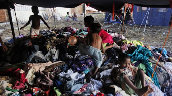 Ethnic Rohingya children play on a pile of clothes donated by local residents at a temporary shelter in Langsa, on Monday.