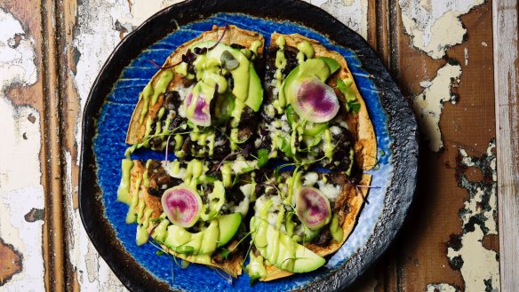 Tlayuda is like a plate-sized tortilla crispbread topped with black bean puree.