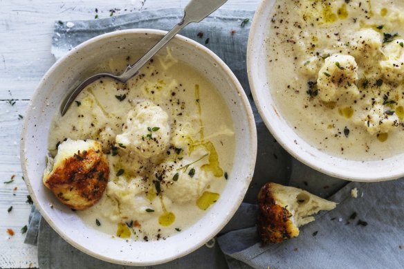 Creamy cauliflower cheese soup pictured with pieces of parmesan and thyme monkey bread (see recipe below).