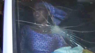 A rescued woman sits in a vehicle with bullet hole in its windshield near the Splendid Hotel in Ouagadougou. 