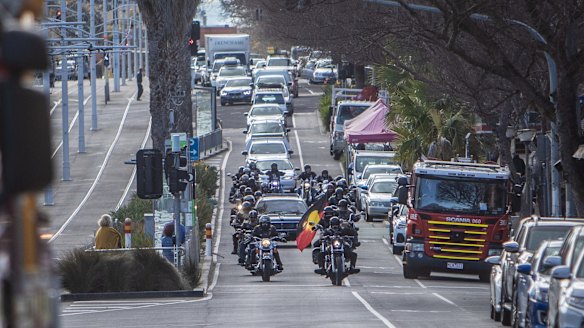 The hearse being escorted down Fitzroy street in St Kilda.
