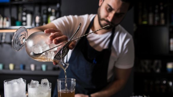 PS40's bartender mixes up some cocktails.