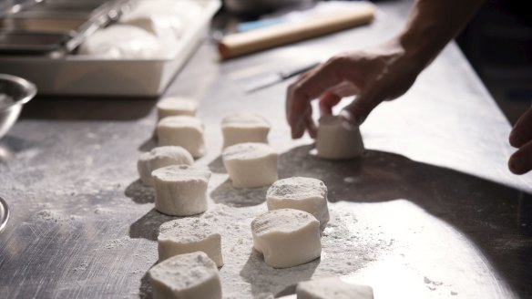 Use scales to weigh the first couple of dough pieces to roughly 65g and divide the remaining dough into similar sized pieces. 