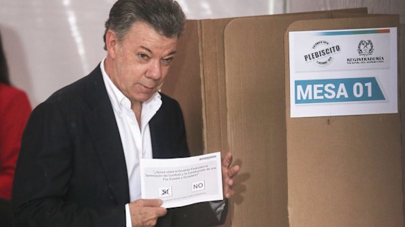 Colombian President Juan Manuel Santos holds his ballot paper in the referendum.