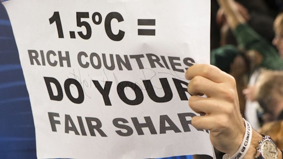 A poster demanding that warming be limited to 1.5 degrees, held up during a protest by activists at the Paris climate talks.