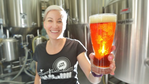 Jayne Lewis from Two Birds Brewing with a glass of Sunset Ale.