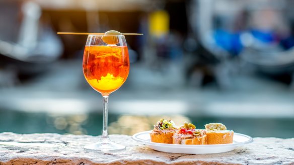 Aperol spritz with cicchetti (traditional Venetian snacks) on the canal in Venice. 