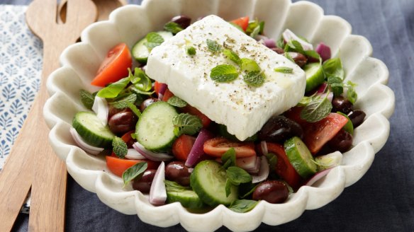 Greek salad topped with a slab of Greek feta (