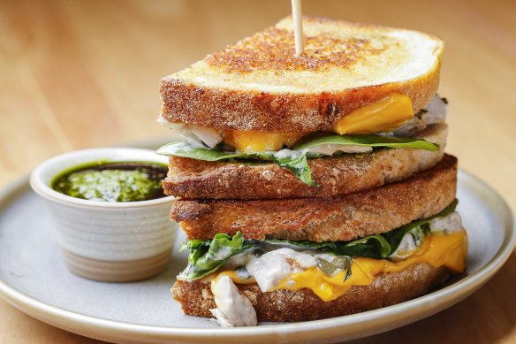The chicken sandwich, pictured with optional American cheese, is served with salsa verde on the side.
